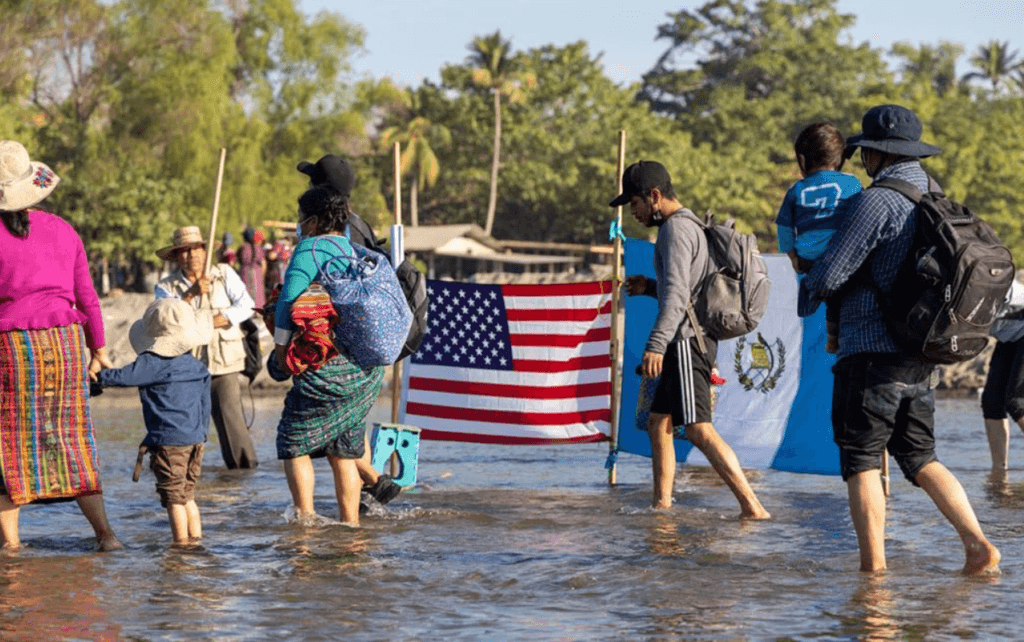 Migrants walk past Guatemalan and U.S flags set in the Suchiate River, which separates Mexico and Guatemala. Some call nearby Tapachula, Mexico, the “new U.S. border,” as more and more migrants are coming to the U.S. from other countries and crossing Mexico to get here. (File photo by Drake Presto/Cronkite Borderlands Project)
